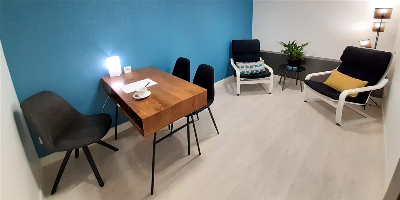 Salle de consultation avec bureau en bois et deux fauteuils